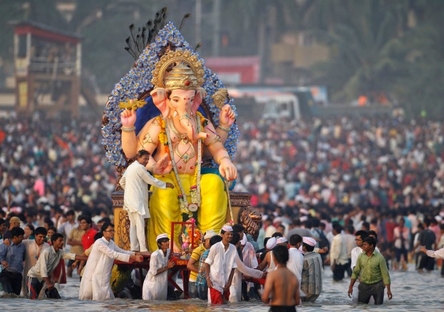 Les fidèles portent la statue de Ganesh dans la mer lors du festival de Ganesh Chaturthi en Septembre 2014 à Bombay
